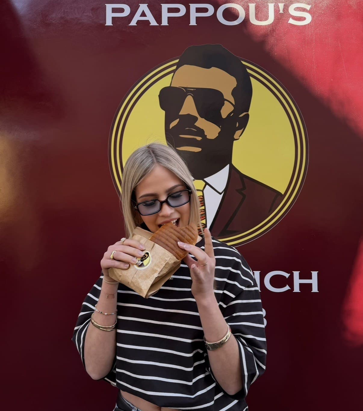Gast beißt in ein Pappou’s Sandwich vor dem Truck